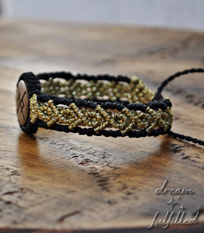 vista lateral de pulsera de madera e hilo negro y dorado grabada con la runa vikinga de amor eterno