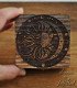 small wooden box engraved with sun, moon, stars, and lunar phases, top view of lid
