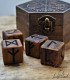 vista frontal de caja hexagonal de madera y cuatro dados grabados con las 24 runas del Futhark antiguo