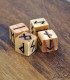 four light-colored wooden dice engraved with the 24 runes of the ancient Futhark