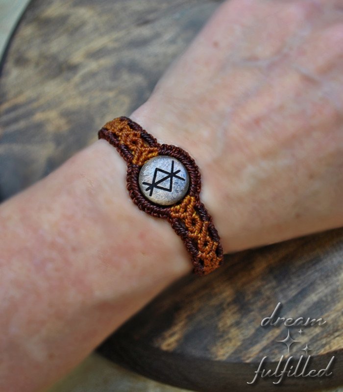 pulsera grabada con runa de protección, hecha de hilo trenzado color naranja y marrón y pieza central de madera