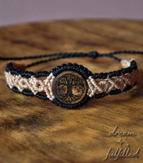 front view of a wooden bracelet with black and beige braided cord, engraved with the Tree of Life symbol