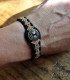 a wooden bracelet with black and beige braided cord, engraved with the symbol of the Tree of Life