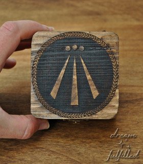 Dark wooden box with engraved Awen symbol in center and metal latch, top view showing details of engraving.