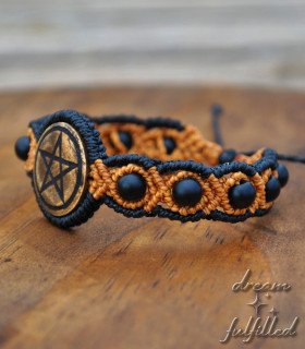 An orange and black macramé bracelet with intertwined matte black onyx beads, engraved with the pentacle symbol