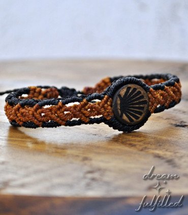 brown wooden and braided thread bracelet, engraved with the scallop shell symbol of the Camino de Santiago