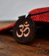 Om pendant on red fabric