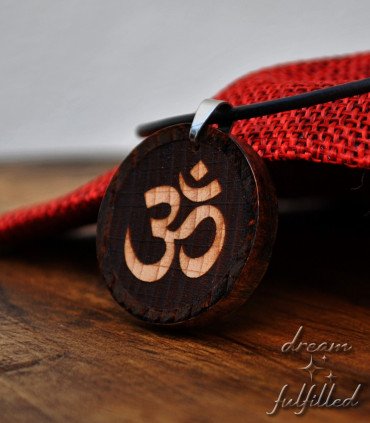 Om pendant on red fabric